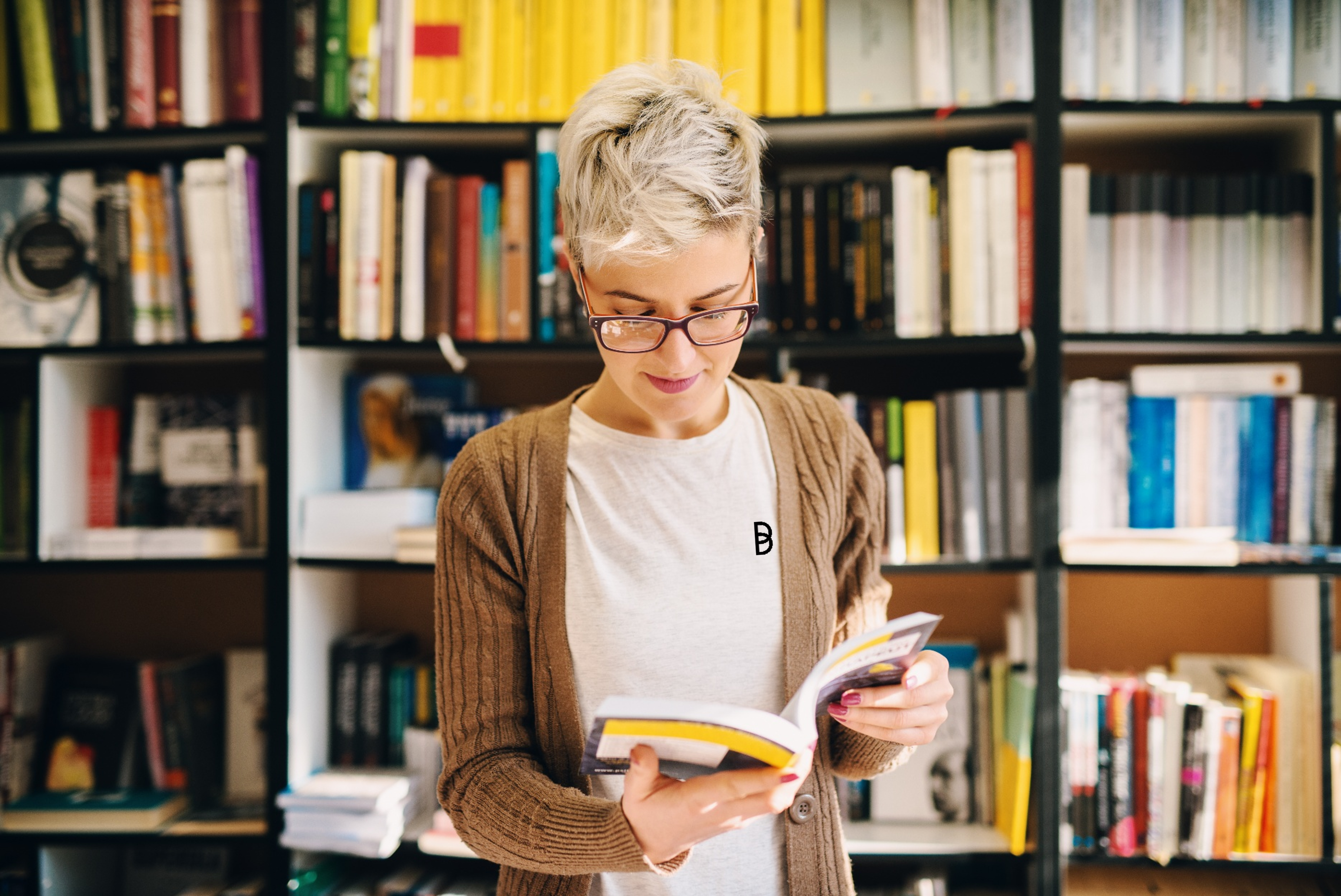 Woman reading a book in a library, representing research, learning, and access to technical knowledge with Ballycatter.